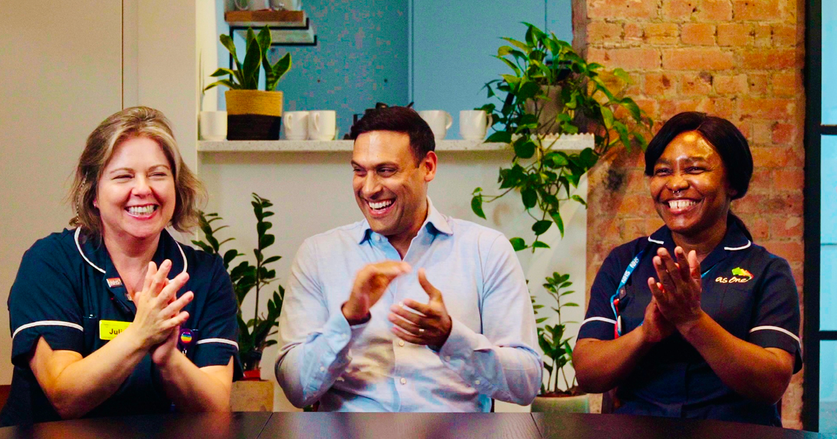a group of people smiling & clapping 
