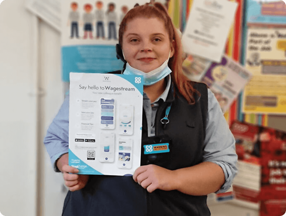 A Co-op employee proudly displays a Wagestream informational pamphlet, showcasing the app's features for improved financial wellbeing.
