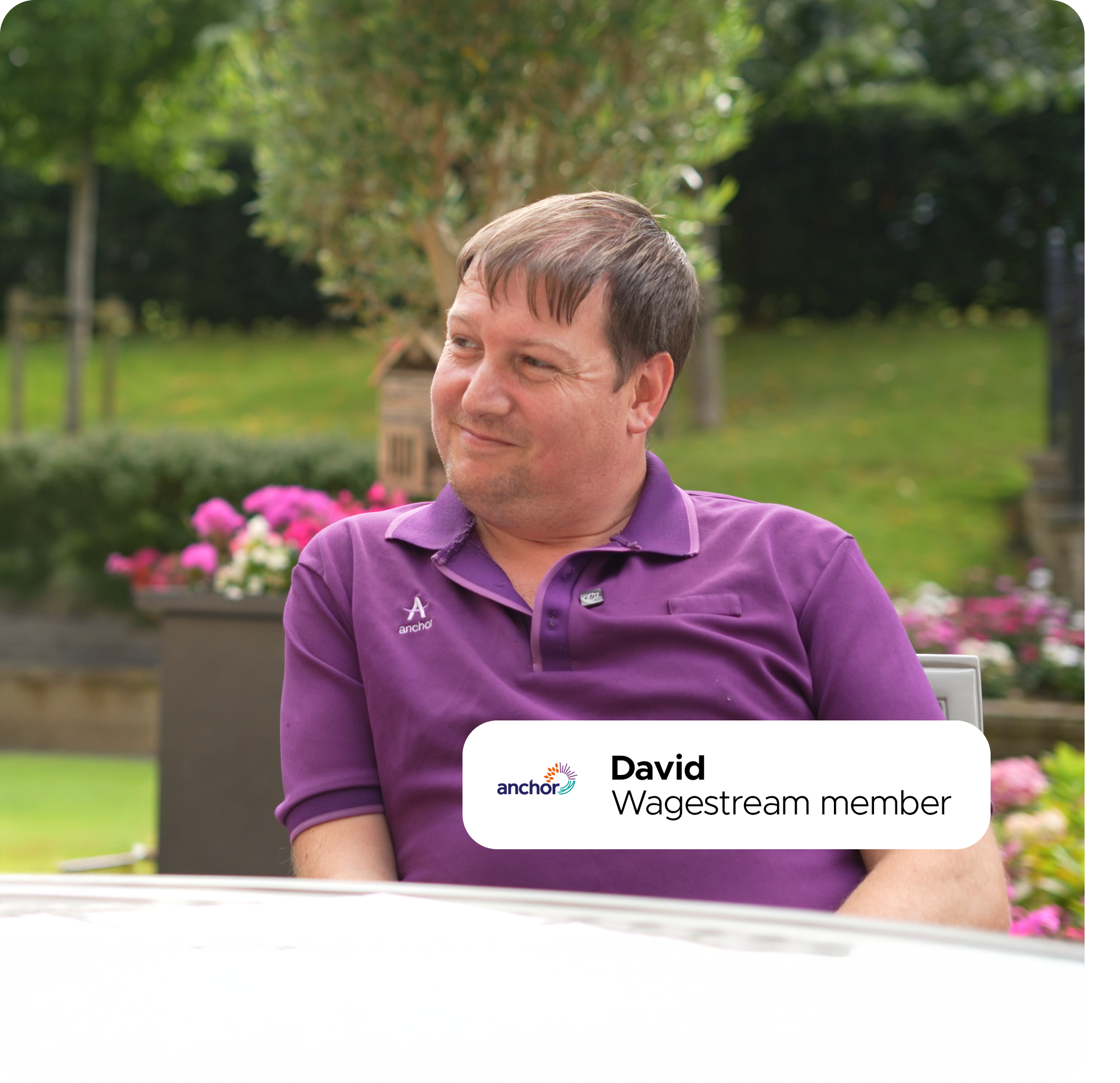 Smiling man, David, Wagestream member, wearing purple polo shirt outdoors.
