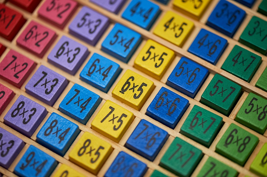 Wooden multiplication table with colorful blocks showing multiplication facts.
