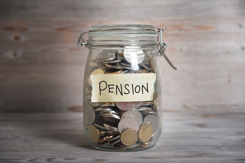Glass jar filled with coins labeled "Pension" representing retirement savings.
